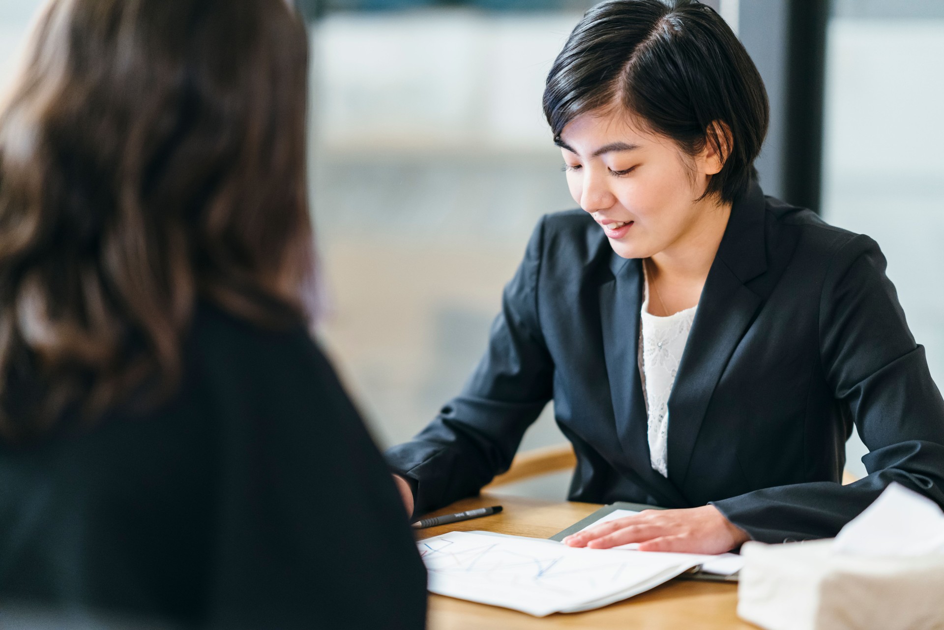 Japanese business consultant giving advice to her client at home